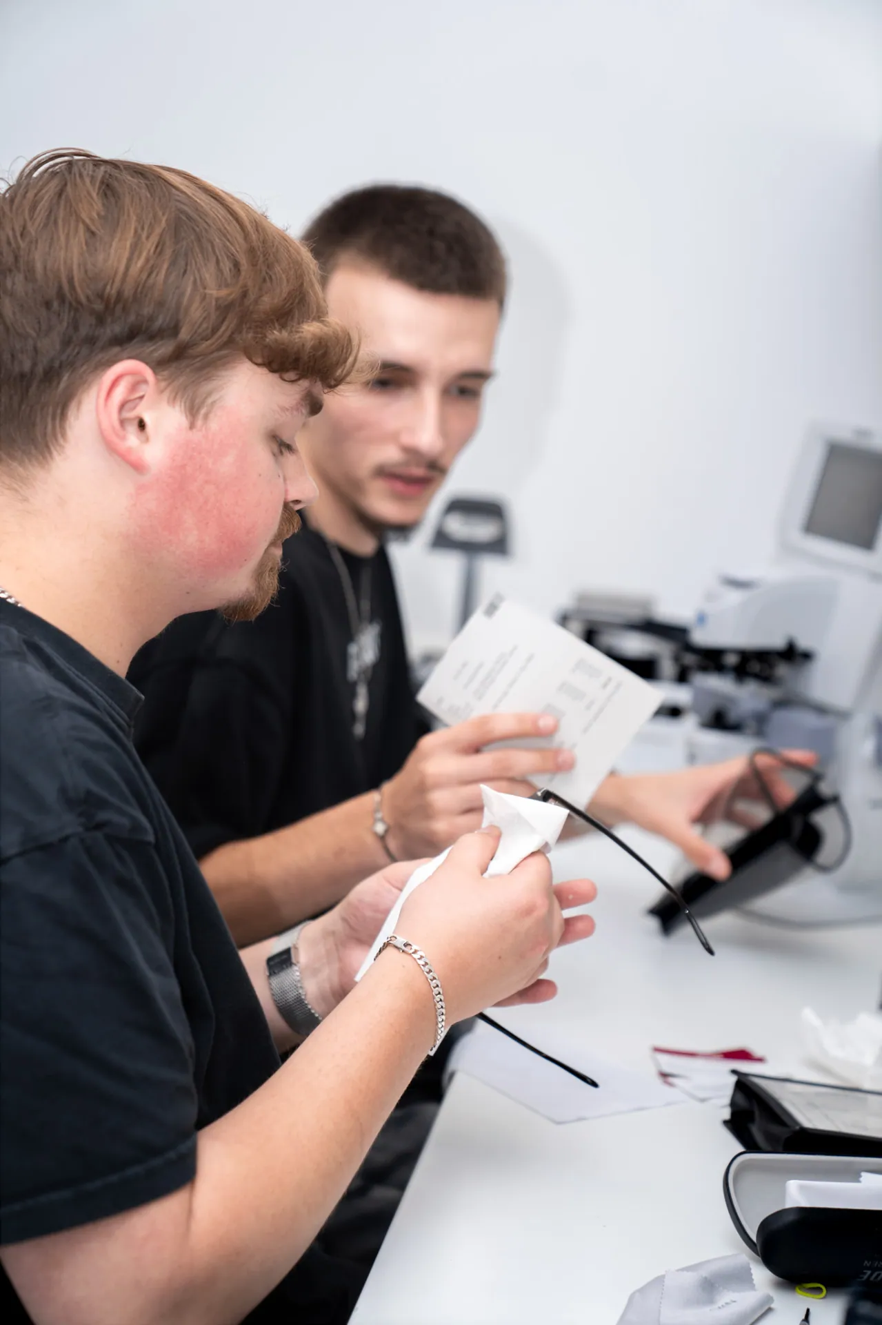 Zwei GRONDE Auszubildende arbeiten in der Werkstatt an einer Brille