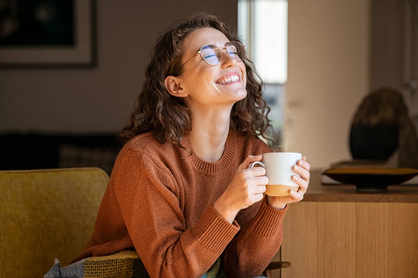 Zufriedene GRONDE Kundin mit Brille genießt eine Kaffeepause
