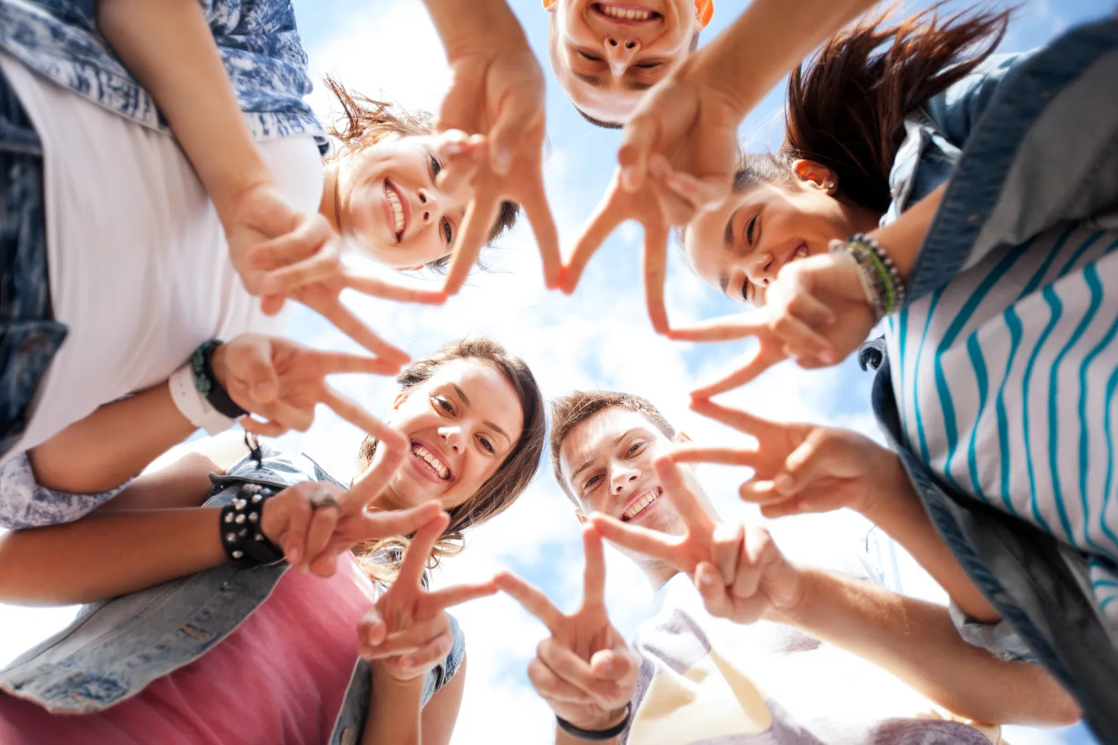 Junge Menschen halten lachend Peace-Zeichen — GRONDE-Gemeinschaft