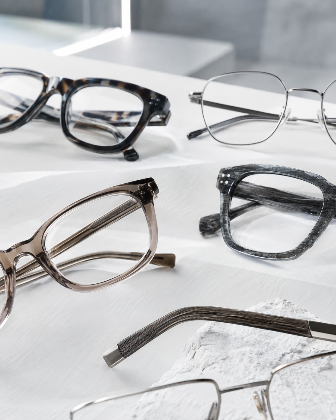 Verschiedene Brillenfassungen aus Acetat, Metall und Holz