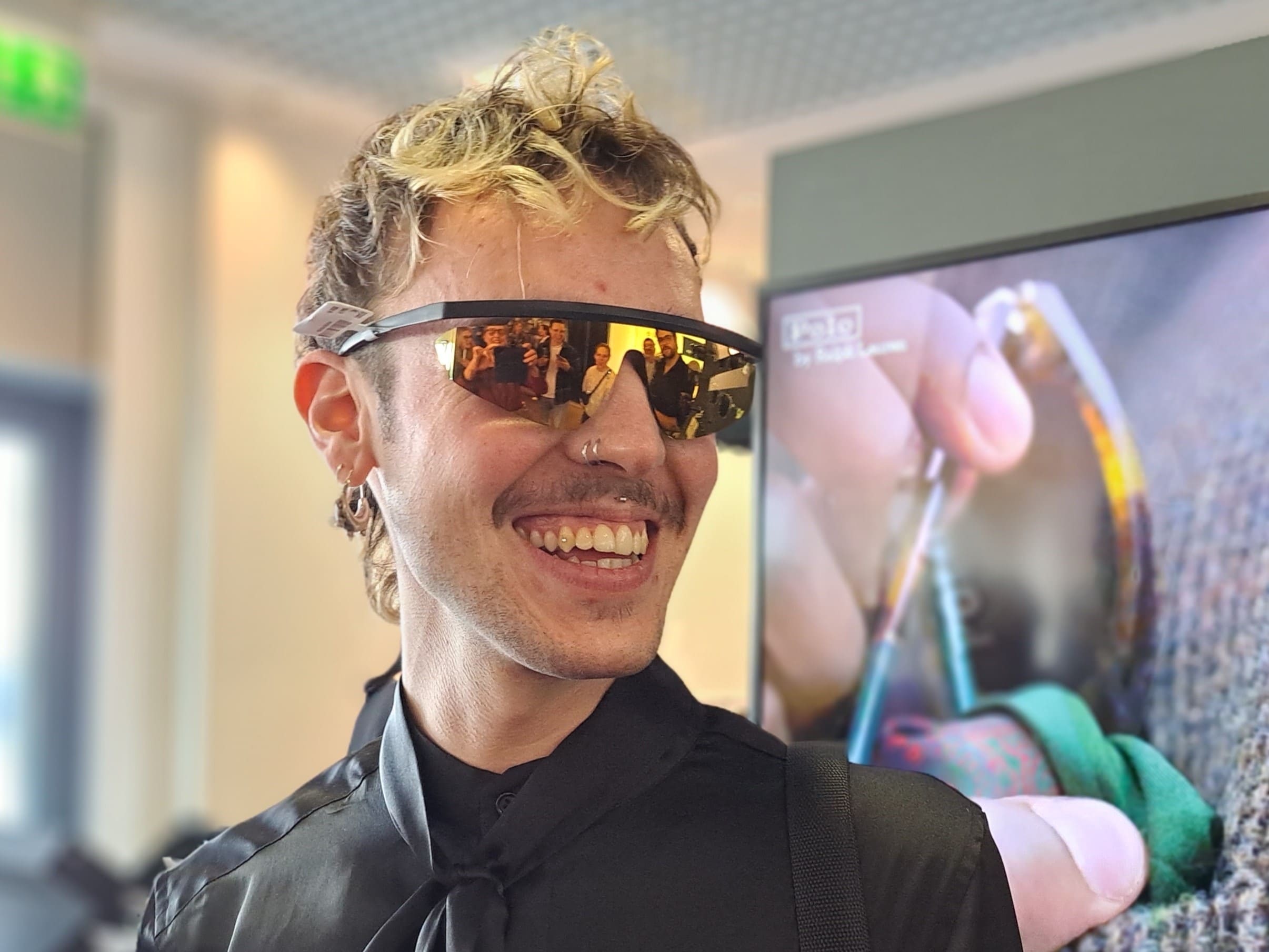Junger Mann mit sportlicher Sonnenbrille zeigt Brillentrend 2024 "athleisure" im Blog von Optiker Gronde
