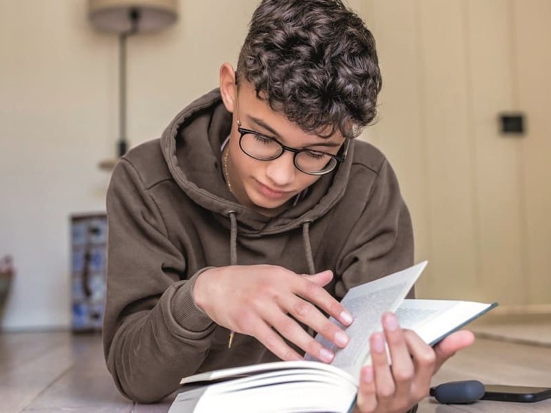 Junge liest mit MiyoSmart Brillengläsern von GRONDE Sehen & Hören