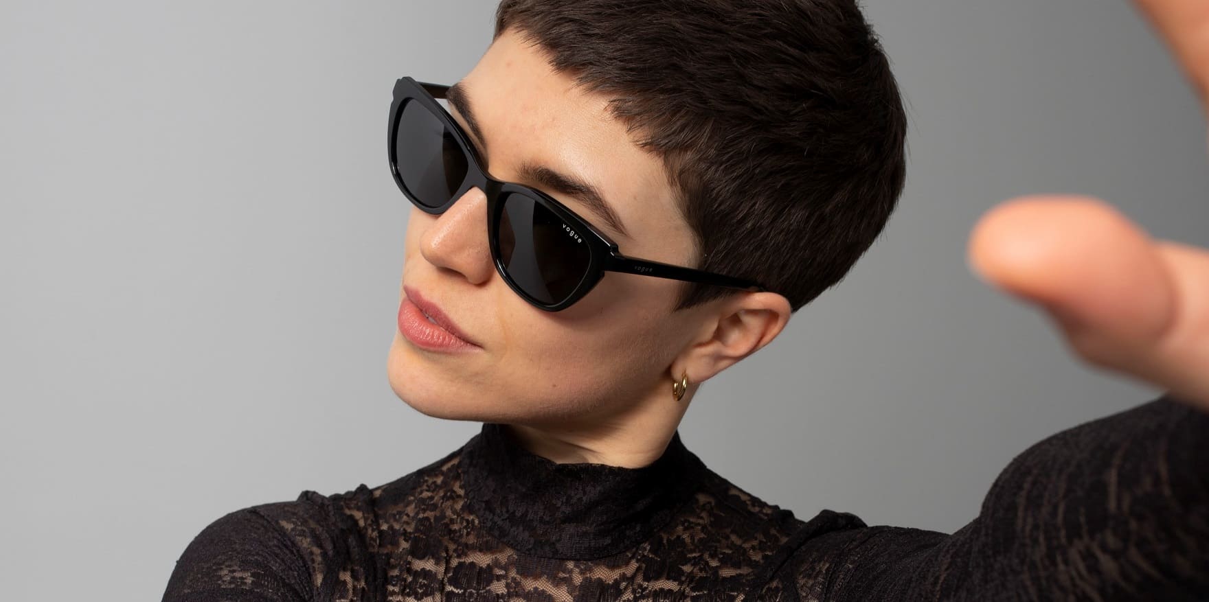 Junge kurzhaarige Frau mit schwarzem Spitzen-Shirt und Vogue Sonnenbrille VO5293S von Optiker Gronde
