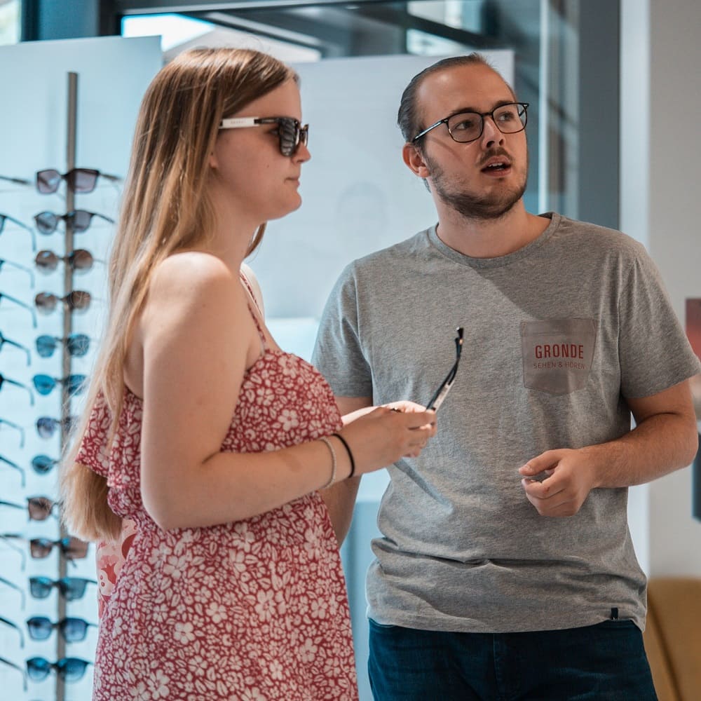 Junger Optiker berät Kundin bei der Wahl der Sonnenbrille, Optiker Gronde Azubi-Tage 2022
