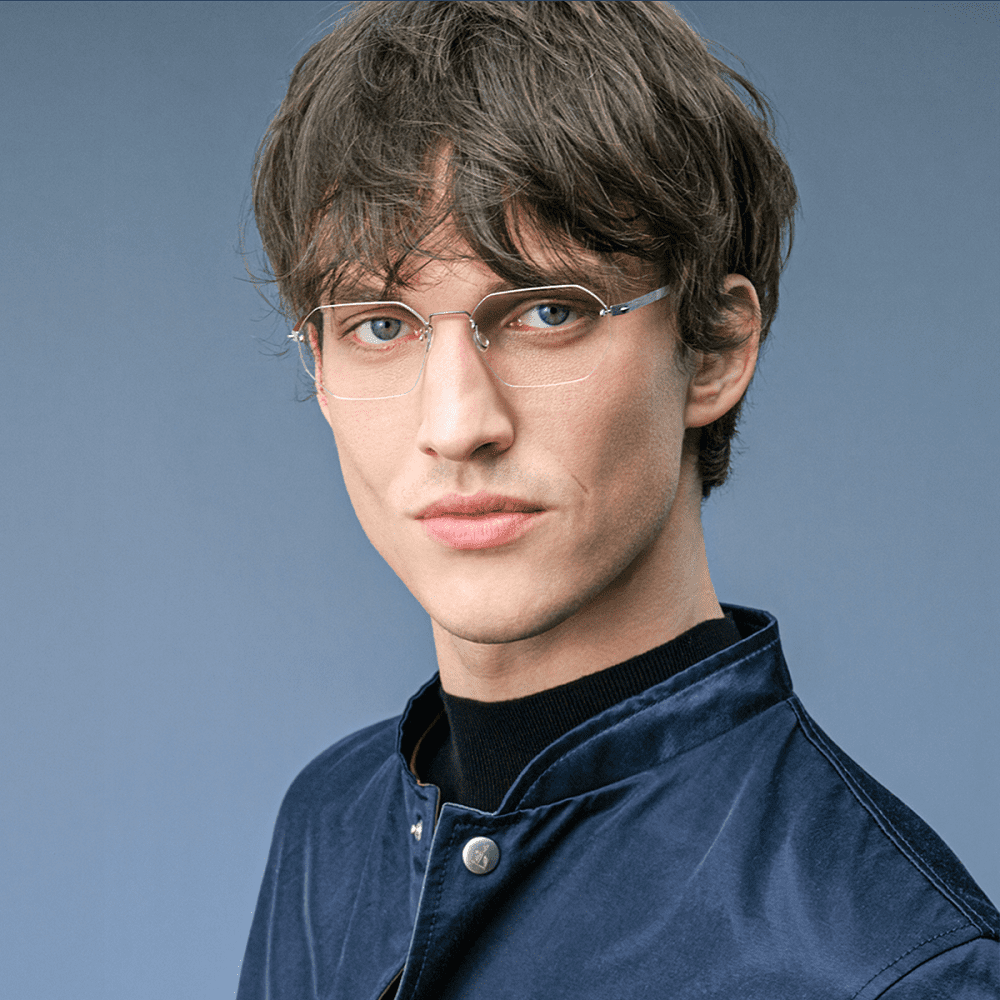 leichte hellgraue Lindberg Brille von Optiker Gronde an jundem Mann mit blauen Augen und blauer Jacke 
