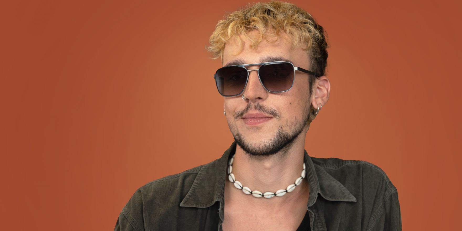 Junger Mann mit kurzen blonden Locken und günstiger EyeAm Sonnenbrille mit Sehstärke von Optiker Gronde