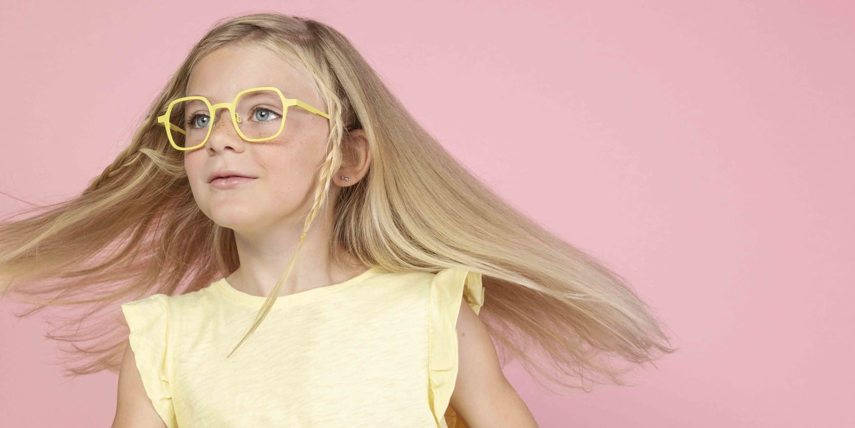 Kinderbrillen. Blondes Mädchen mit fliegenden Haaren und Kinderbrille von Optiker Gronde
