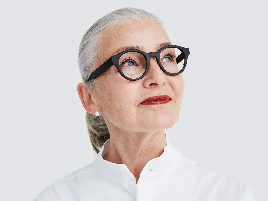 Attraktive ältere Frau mit kräftiger schwarzer Prodesign Brille von Optiker Gronde