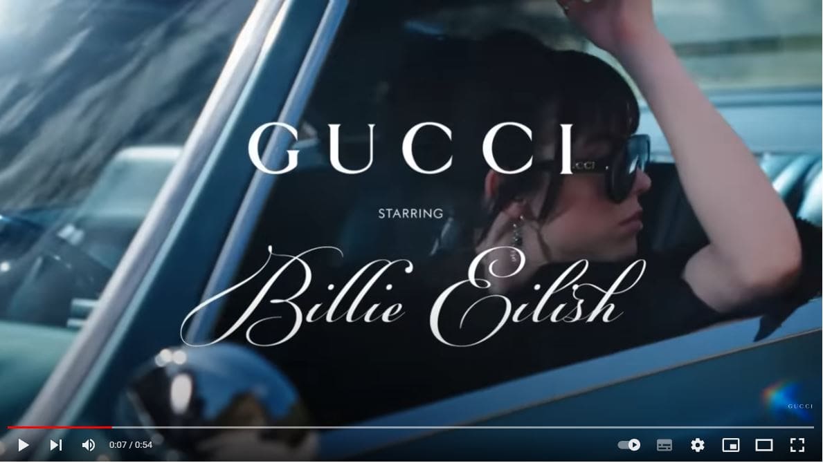 Startbild des Gucci-Videos mit Billie Eilish im Oldtimer mit großer Gucci Sonnenbrille. 