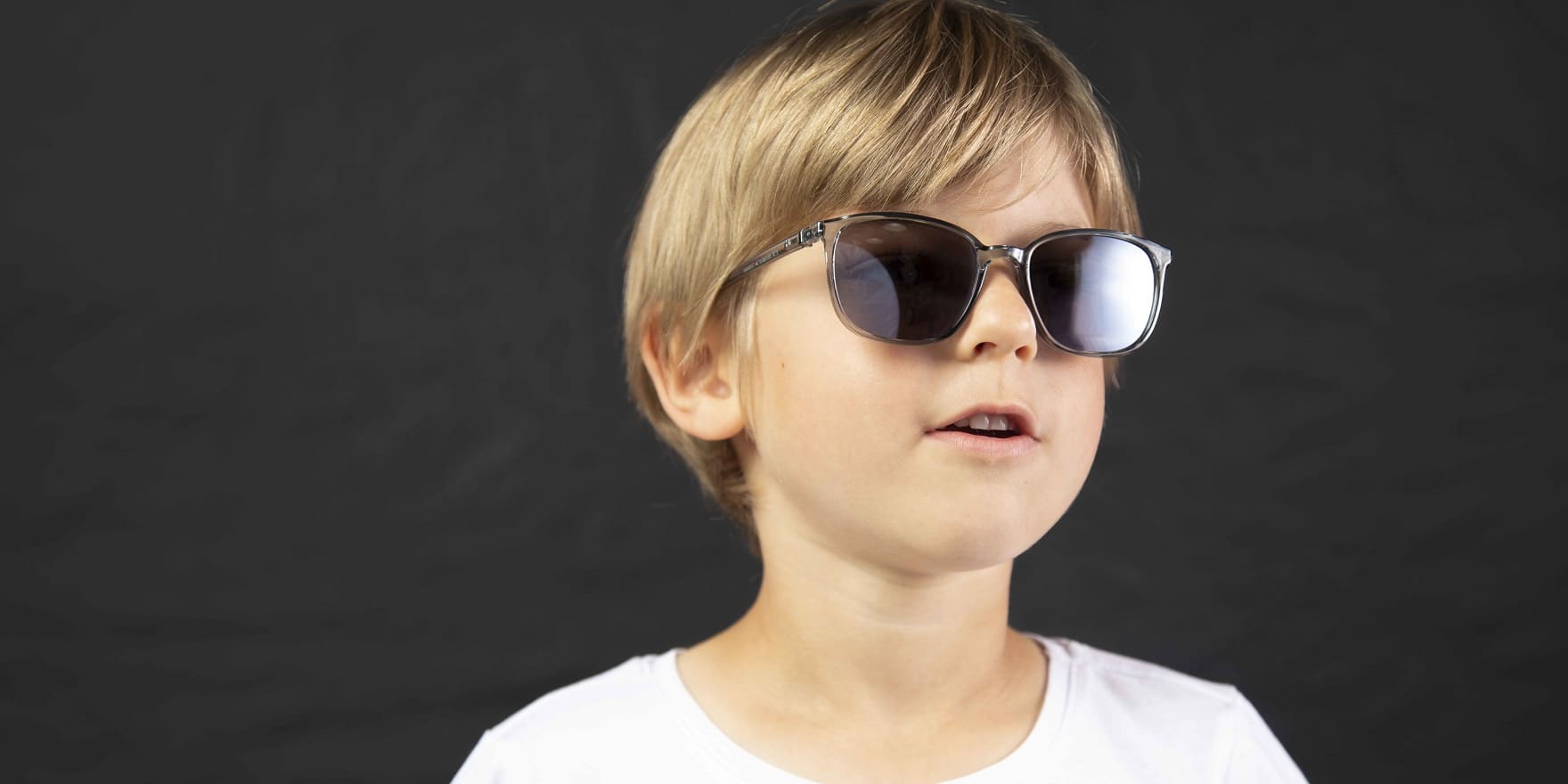 Blonder Bub mit dunkler Kinder-Sonnenbrille von Optiker Gronde