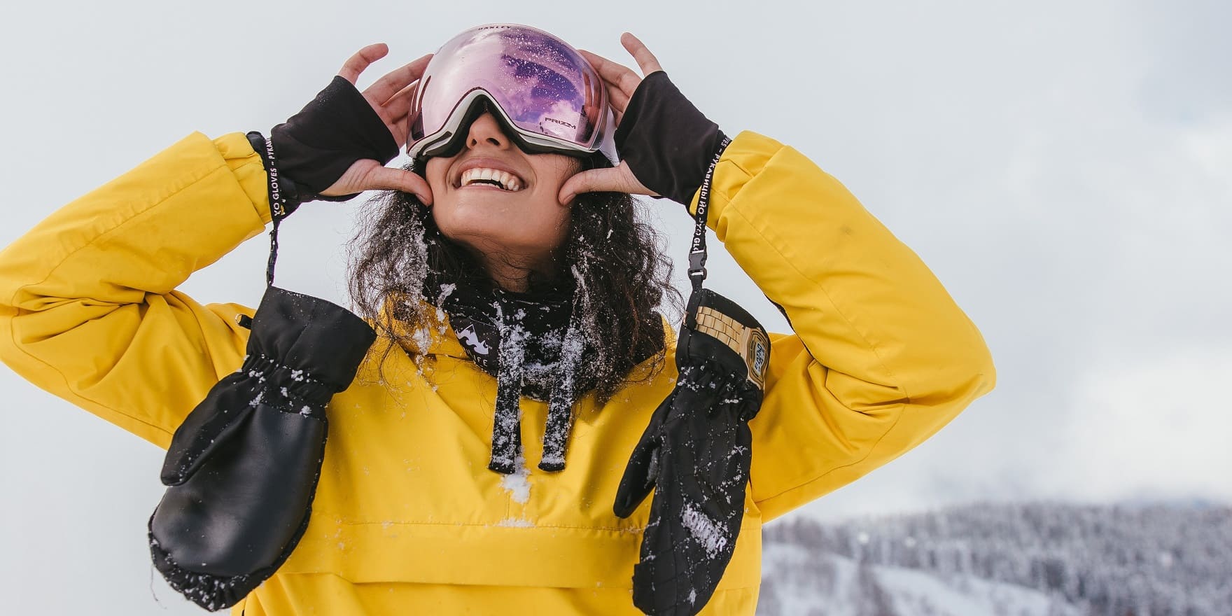Junge Frau mit gelbem Overall und Skibrille von Optiker-Gronde im Schnee