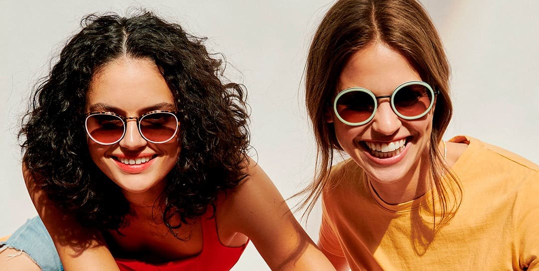 Zwei junge Frauen tragen runde Etnia Sonnenbrillen von Gronde Sehen und Hören
