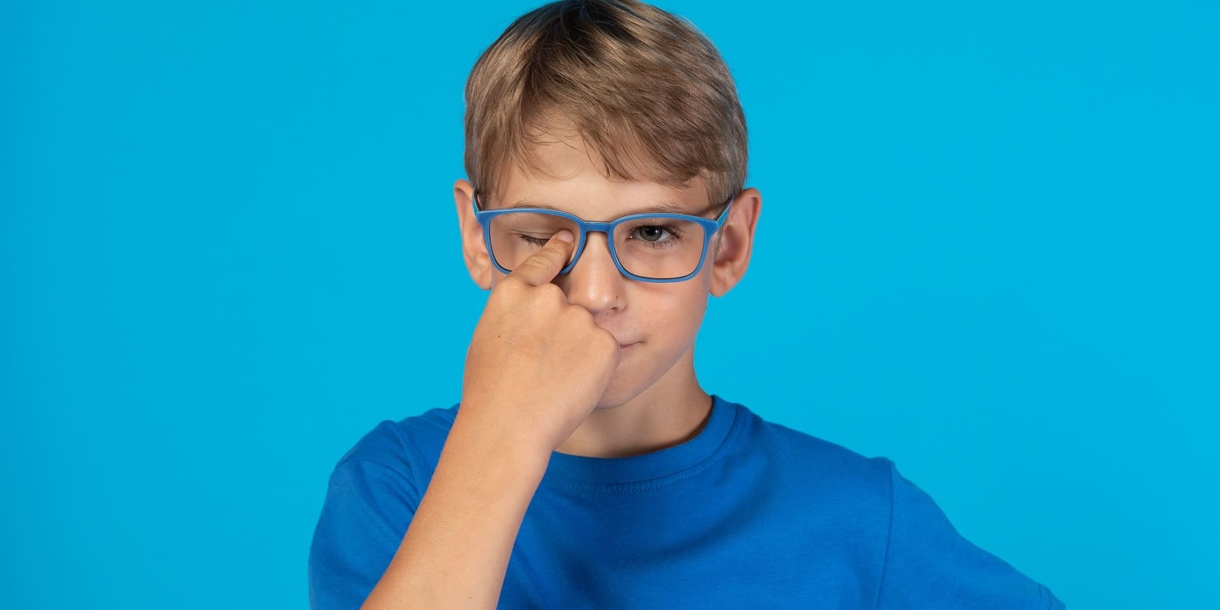 Junge mit blauer Brille ohne Gläser erklärt Versand und Retoure im Online-Shop von Optiker Gronde