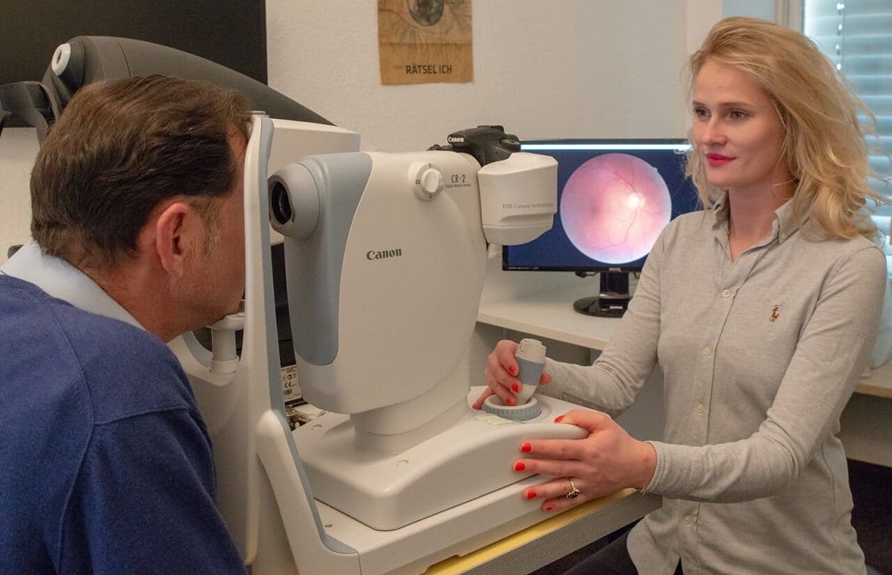 Lena Gronde mit Funduskamdera bei der Untersuchung des Augenhintergrunds. Optiker Gronde, Augsburg