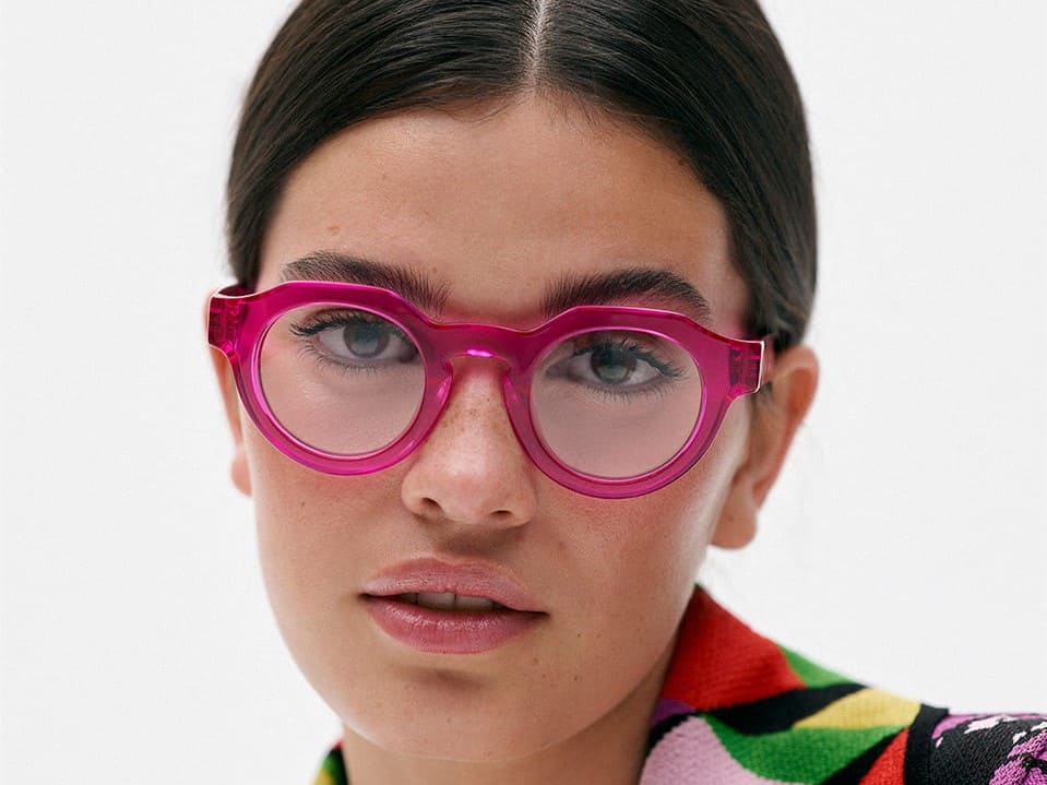 Brillen-Trends 2023 im Blog von Optiker Gronde: leuchtendes Magenta. Große Brille an junger Frau mit schwarzem Pferdeschwanz