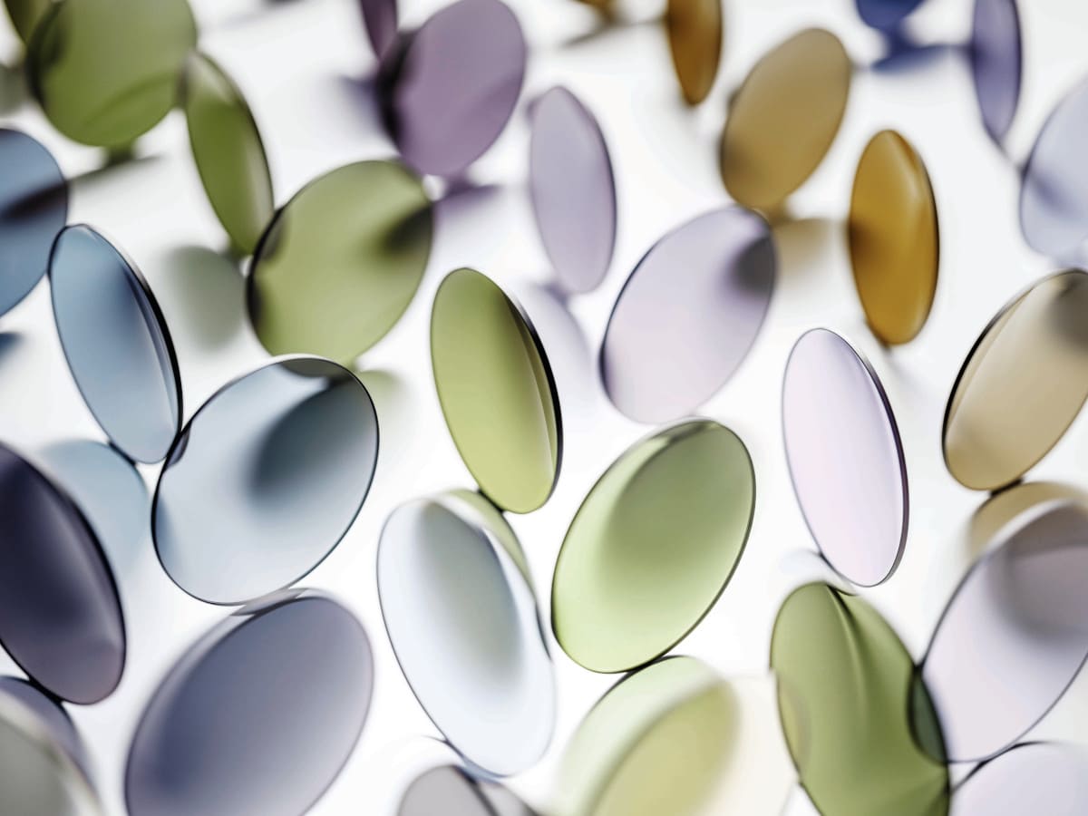 Blaue, grüne, lila und braune Brillengläser sind stehend angeordnet